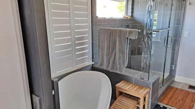 A bathroom at the residence, with a tub and a glass shower