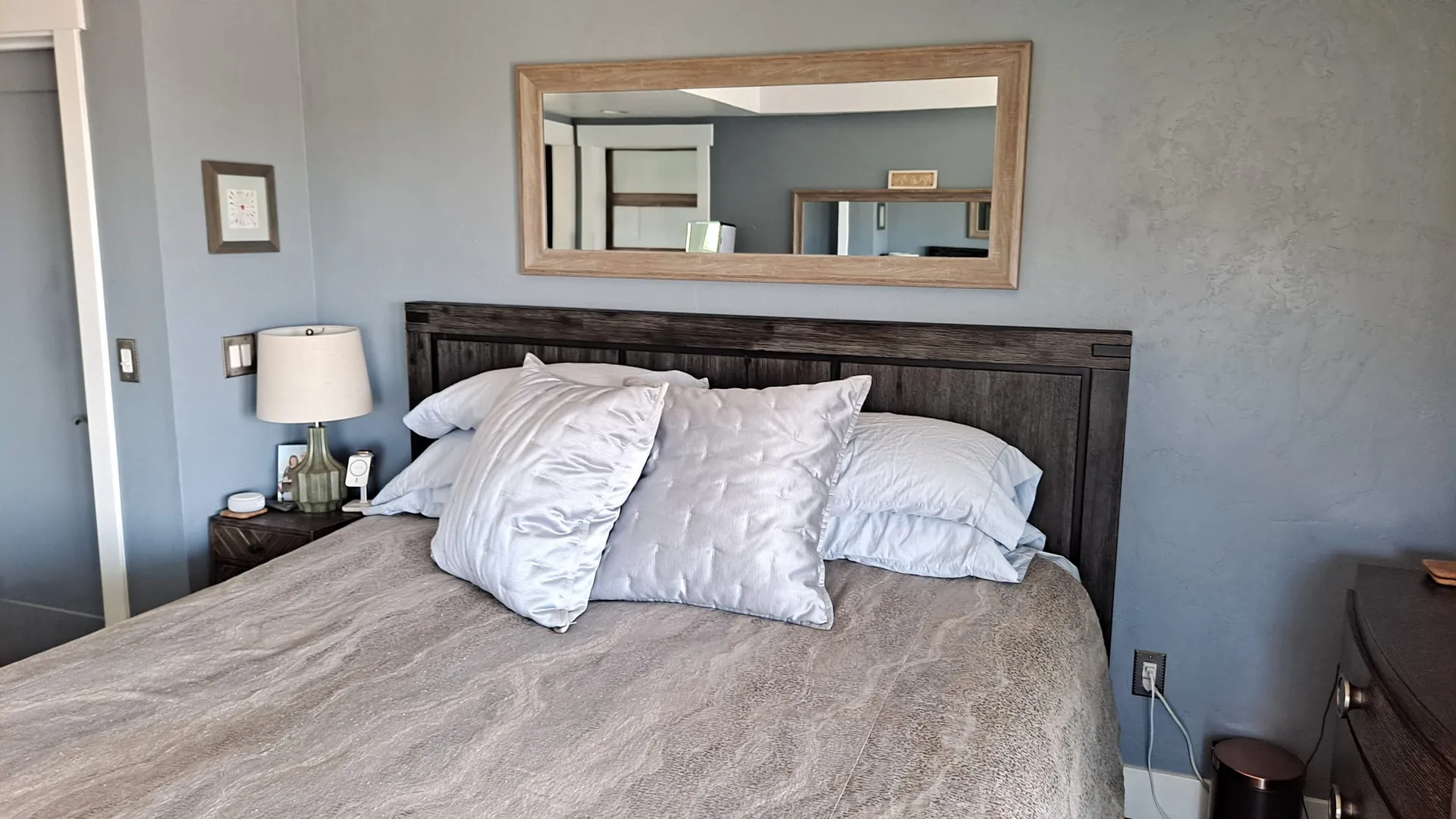 A made bed in a lamplit bedroom at the residence
