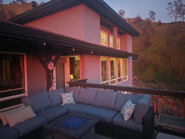 The residence at dusk, with the deck and fire pit overlooking the hillside